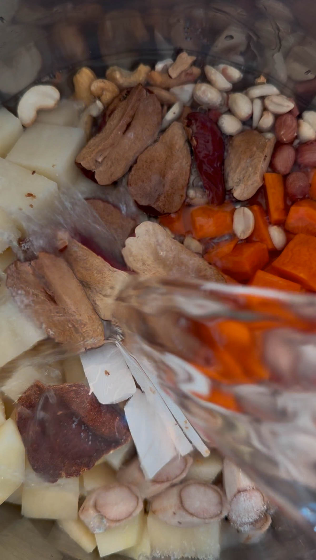 Ingredients to make burdock root soup in the inner pot of an Instant Pot, with water being added.