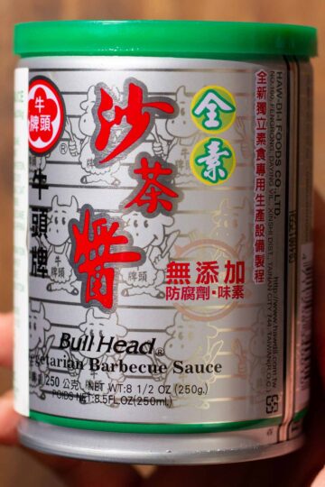 A can of Bull Head Vegetarian Barbecue Sauce with a green lid, featuring Chinese and English text and cartoon cows in the background.