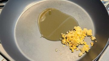 Minced garlic, minced ginger, and oil in a frying pan.