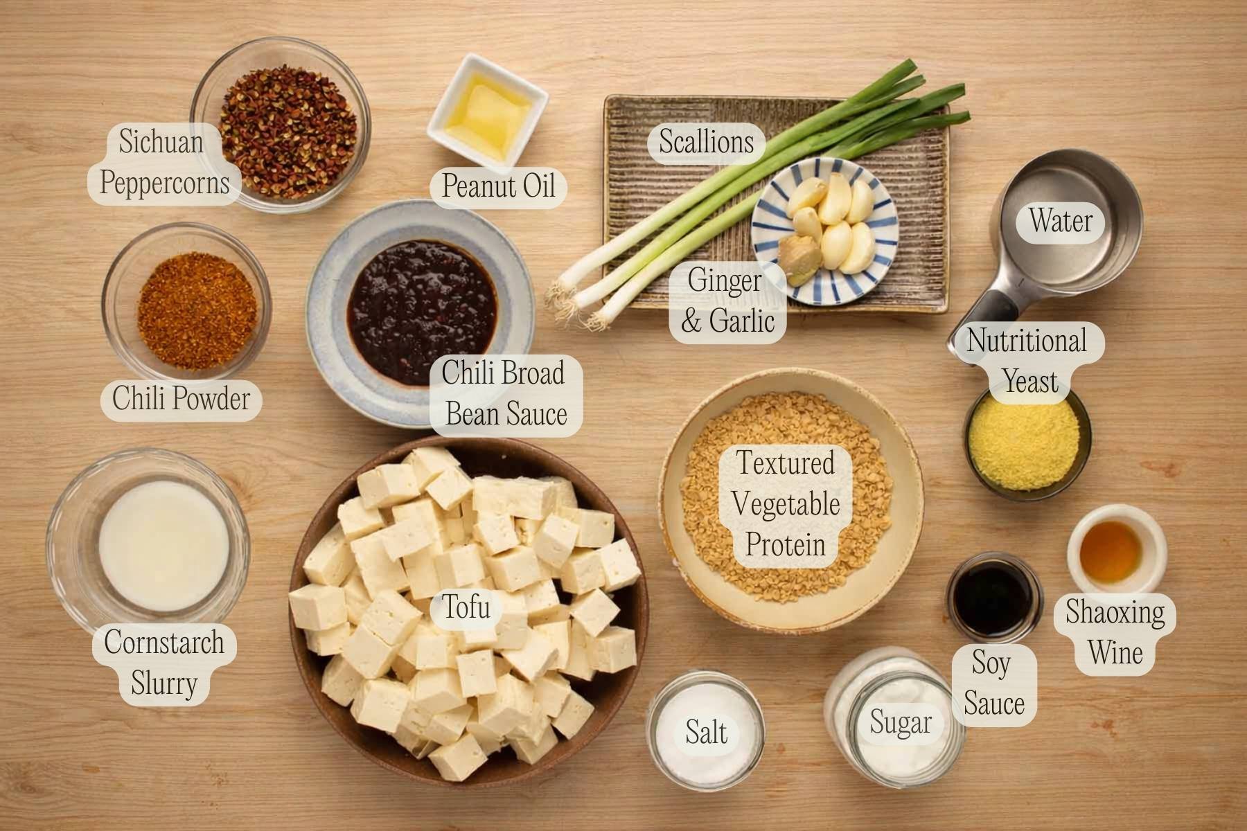 Ingredient needed to make vegan mapo tofu, arranged on a wooden table and labeled.
