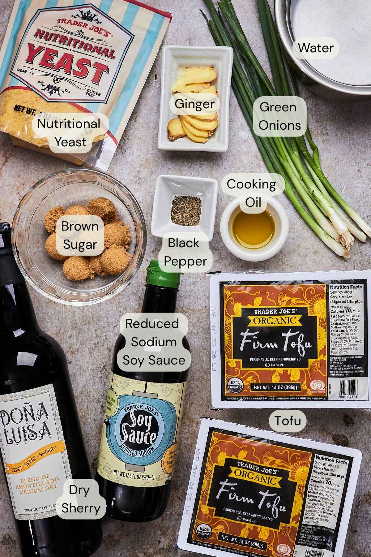 Ingredients needed to make braised tofu laid on a textured surface and labeled.